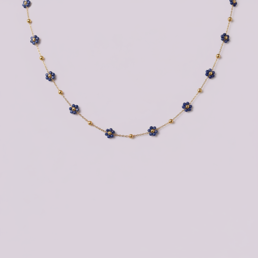 Collier en acier inoxydable doré avec fleurs bleues sur fond lilas