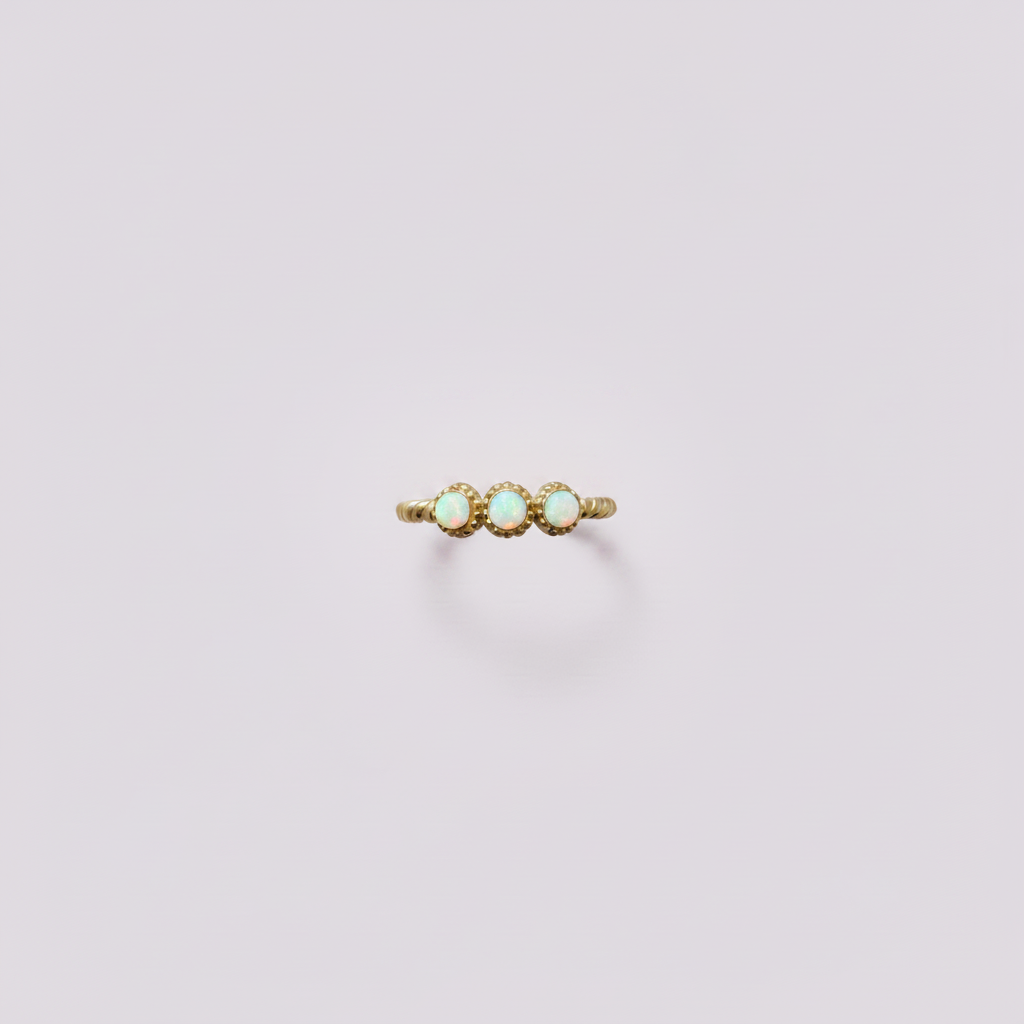 Bague opales dorée fond lilas pâle