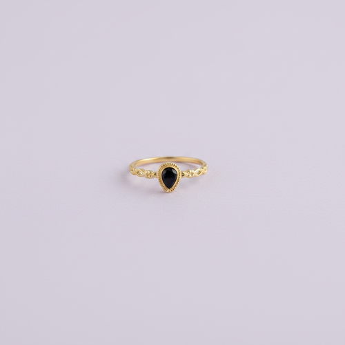 Bague Nour pierre noire dorée fond lilas