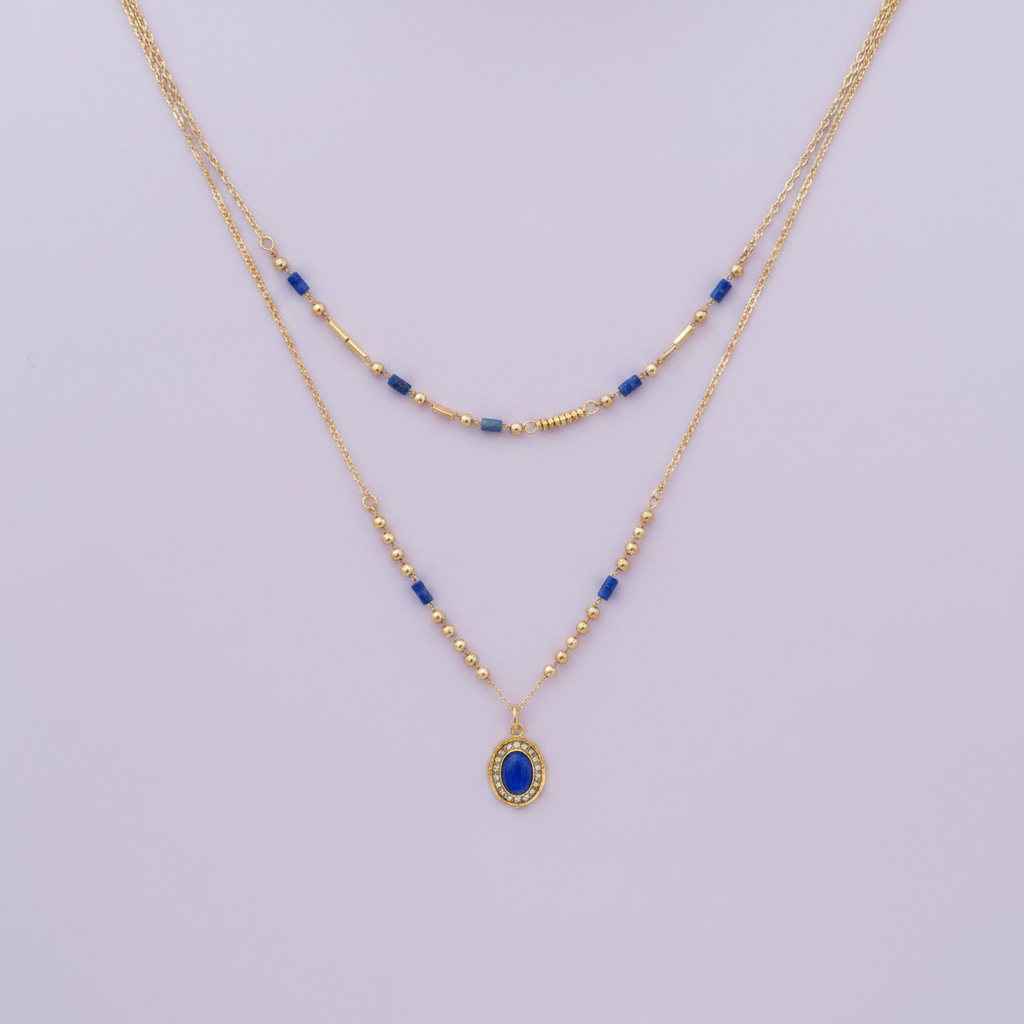 Collier double rang doré avec perles bleues et pendentif médaillon sur fond lilas